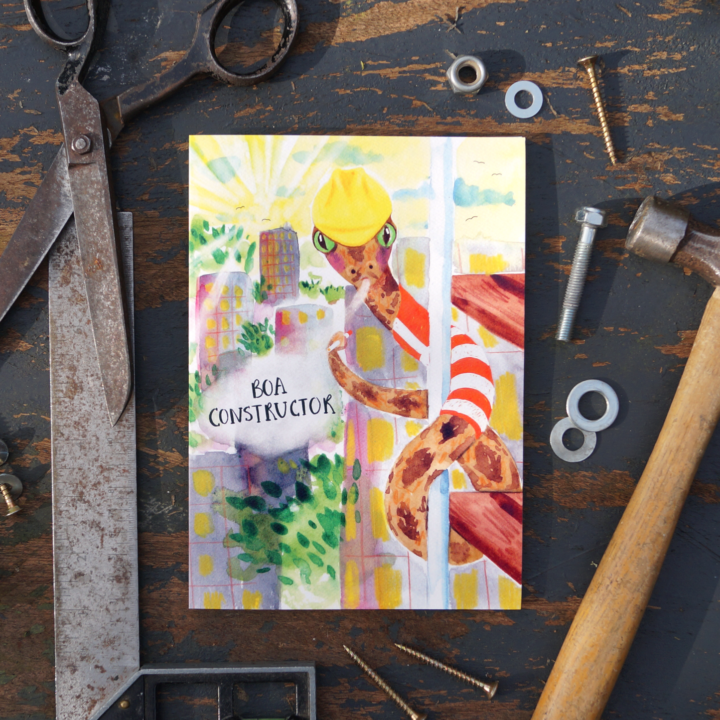 Boa Constructor, construction greetings card featuring a comical Boa-Constrictor wearing a high visibility jacket and hard hat, climbing scaffolding and smoking a cigarette. Perfect for construction workers, builders, handy men, road workers, birthday's, saying thank you or just to make someone laugh. A5 in size and printed on premium quality 300gsm card stock. Designed by luxury gifts and stationery brand, Bella & The Moon.