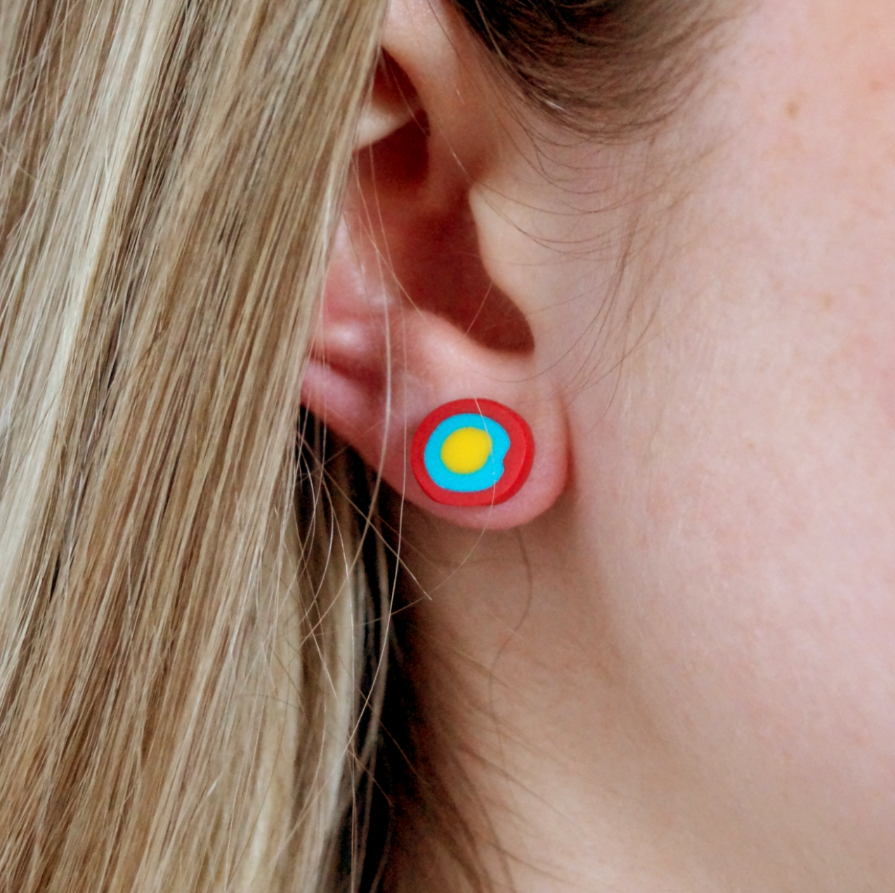Handmade gobstopper stud earrings made from red, blue and yellow clay. Handmade by luxury gifts and stationery brand, Bella & The Moon