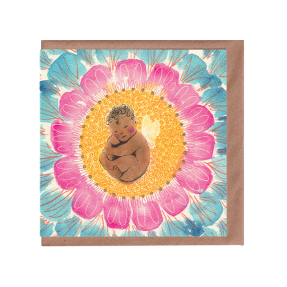 Newborn flower-fairy baby greeting card featuring a brown baby with little wings, sleeping in the middle of a flower of oink and blue petals. It also has hand-detialed gold dots. Square 14cm x 14cm in size. Bella & The Mood gifts and stationery