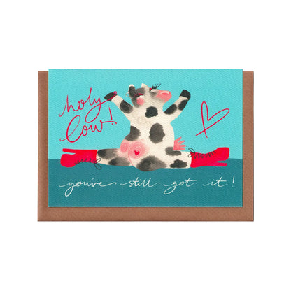 A funny greetings card featuring a cow doing the splits in stiletto heels and the words 'holy cow! You've still got it!'. A comical celebration, birthday or best friend card. A6 in size. Bella & The Moon gifts and stationery.