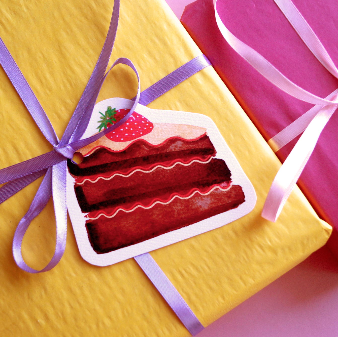A chocolate cake cut-out gift tag tied to a yellow present with ribbon. Present and gift wrapping. Unique and funny gifting ideas. Bella & The Moon gifts and stationery
