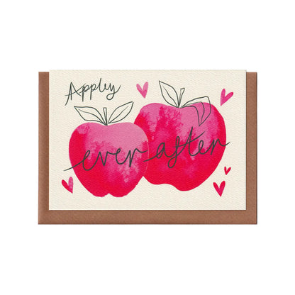‘Appley Ever After’ apple-themed greetings card featuring an apple related pun and two pink watercolour apples surrounded by love hearts. Perfect for weddings, engagements, celebrating love, and Valentine's Day. A6 in size and printed on premium quality 300gsm card stock. Designed by luxury handmade gifts and stationery brand, Bella & The Moon.