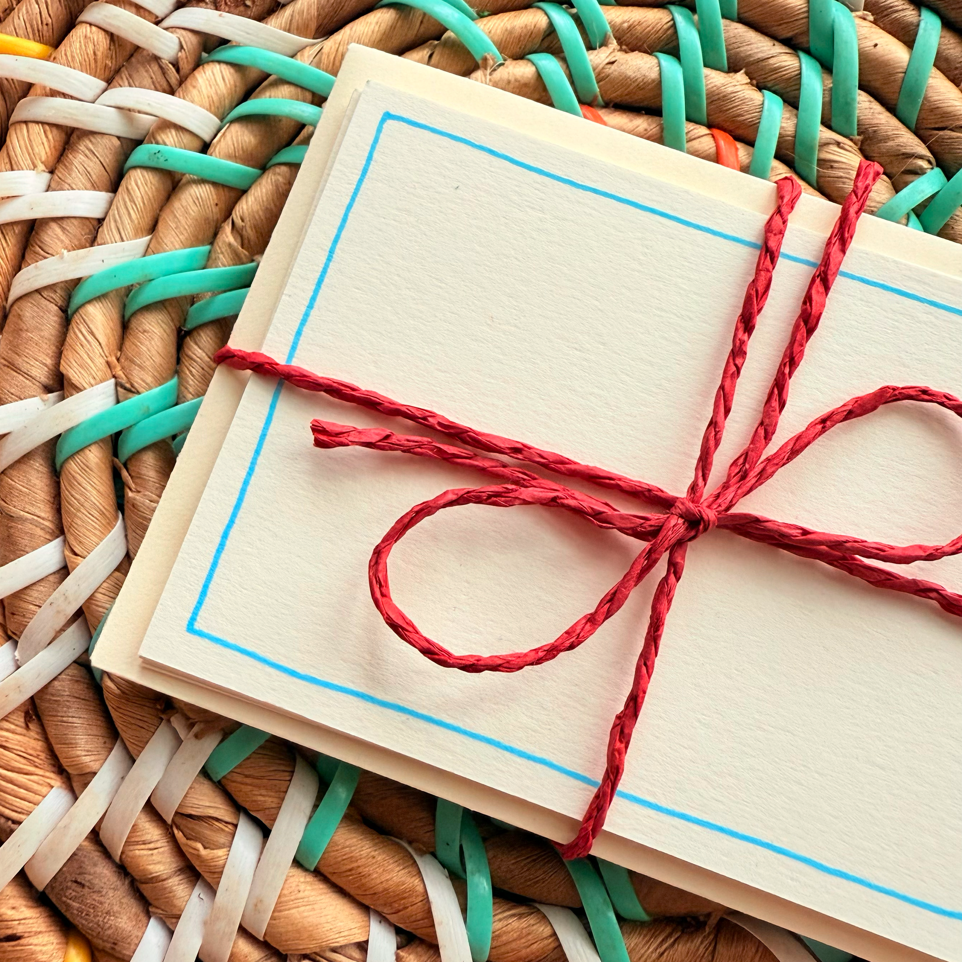 Blue border, hand detailed notecards tied with red string. Sets of 6 notecards and envelopes with hand detailed designs on each card. Gifts for birthdays or to send to friends. A7 in size. Bella & The Moon gifts and stationery