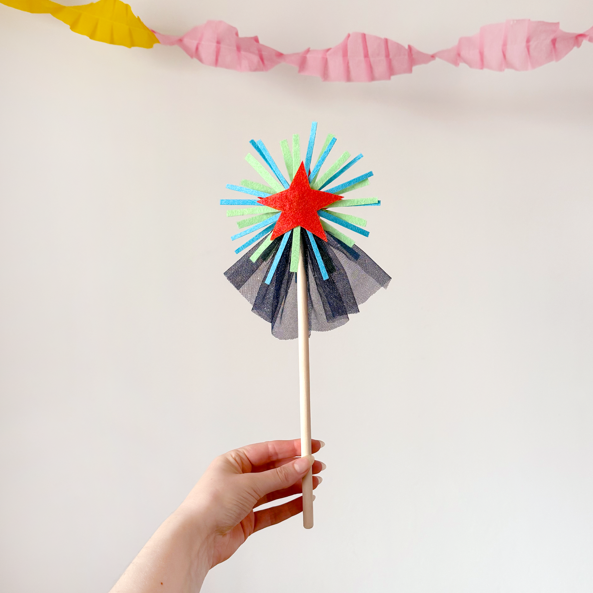 A handmade felt fairy wand featuring an orange star, green details and blue sparkly netting. Great gifts for kids, dressing-up boxes, fancy dress and party bags. Bella & The Moon gifts and stationery. 