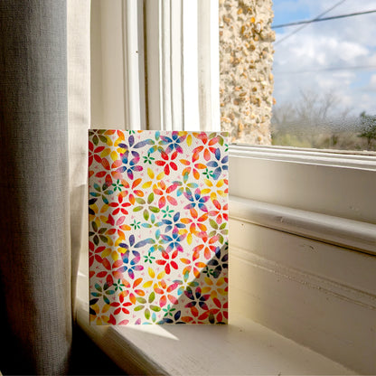 This rainbow blossom greetings card features a vibrant floral design with rainbow-coloured blossoms. Displayed on a sunny window cill. Perfect for birthdays, anniversaries, saying thank you,  spring celebrations or just because. A6 in size and printed on premium quality 300gsm card stock. Designed by luxury handmade gifts and stationery brand, Bella & The Moon.