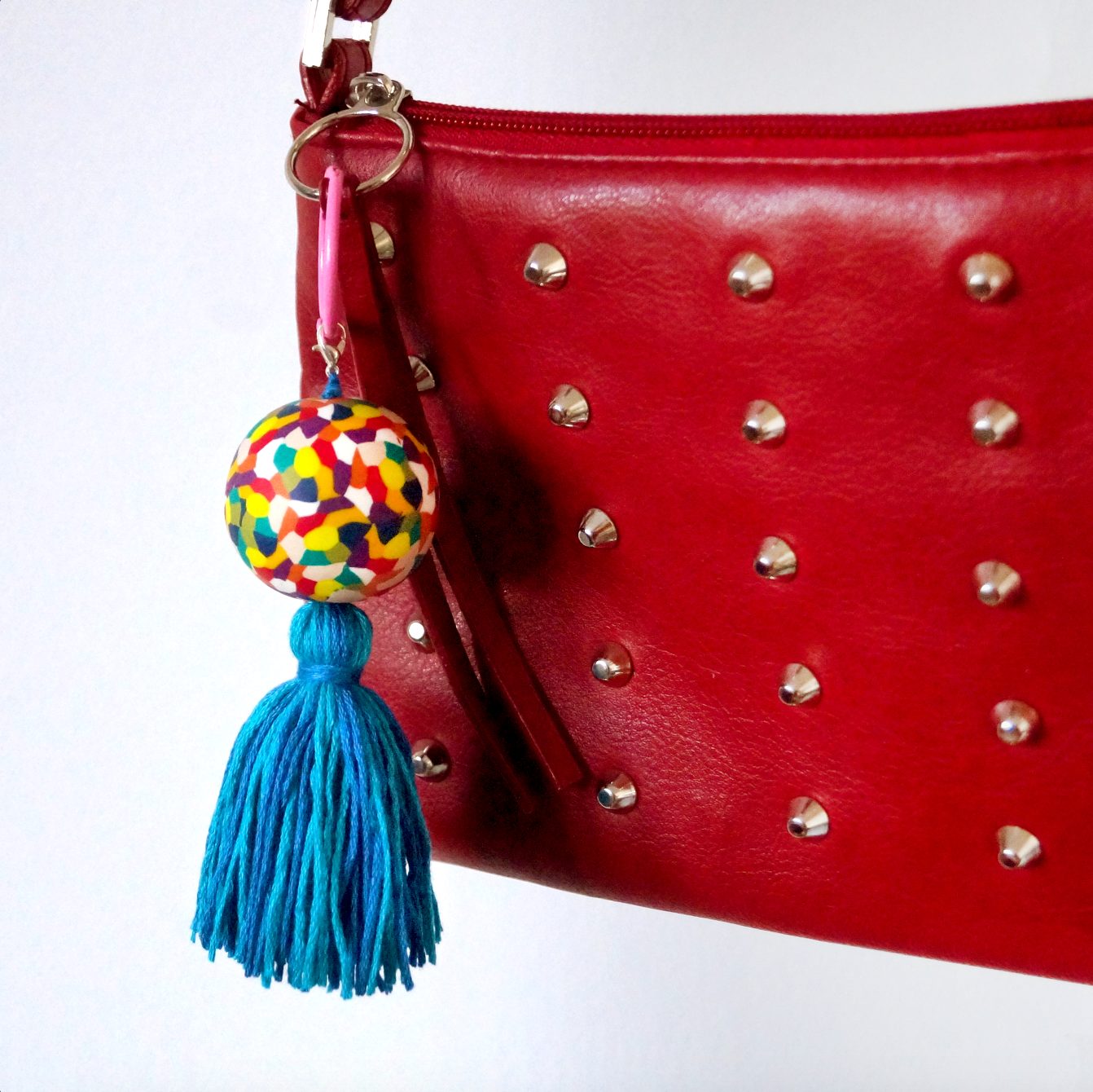 A handmade keyring featuring a colourful handmade polymer bead inspired by the children's elephant character 'Elmer'. It also features a handmade blue tassel. A keyring made to accessorise bags, keys and clothing. Bella & The Moon gifts and stationery